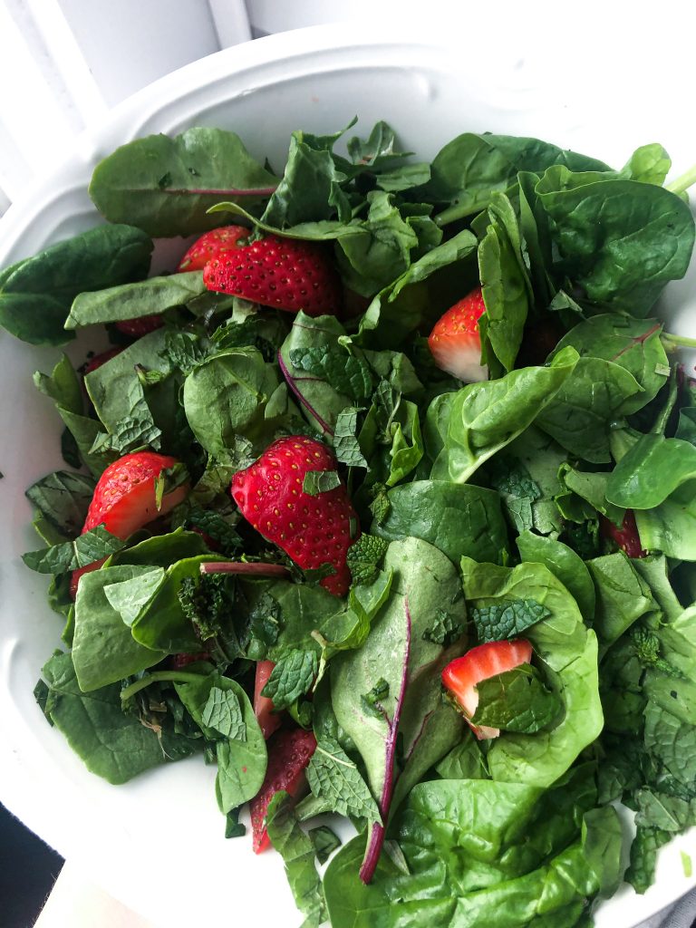 strawberry and mint herb salad in a white bowl.