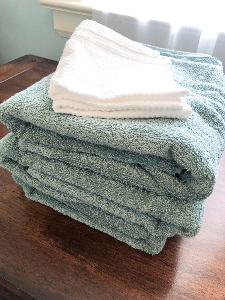 close up of blue green bath towels and white washcloths