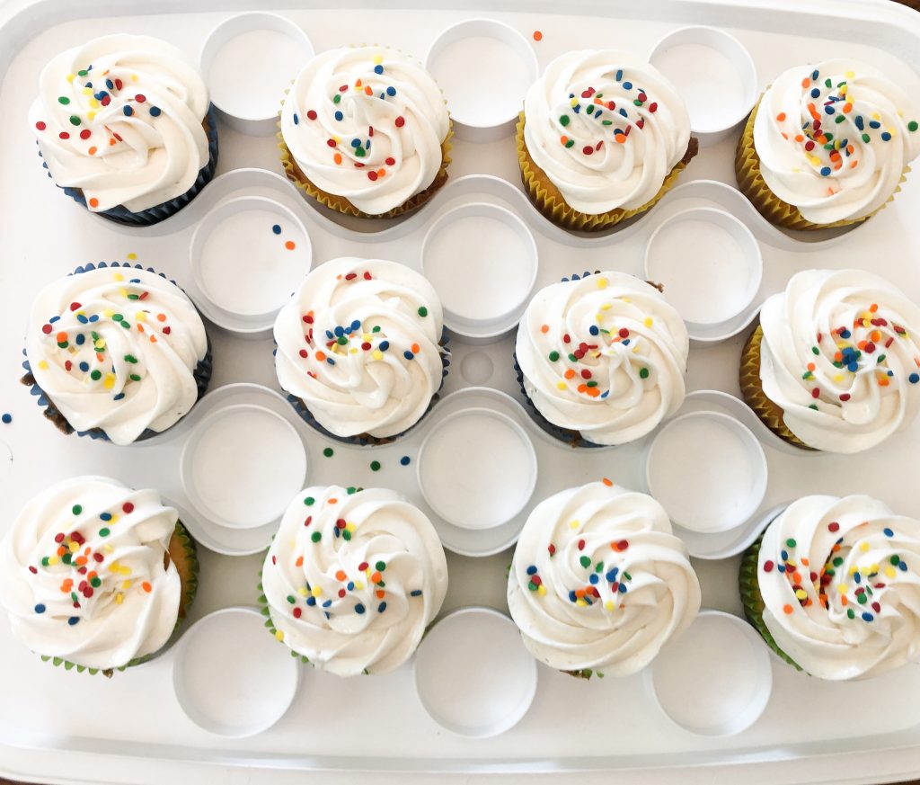12 white and sprinkled cupcakes in a tray for a simple birthday party