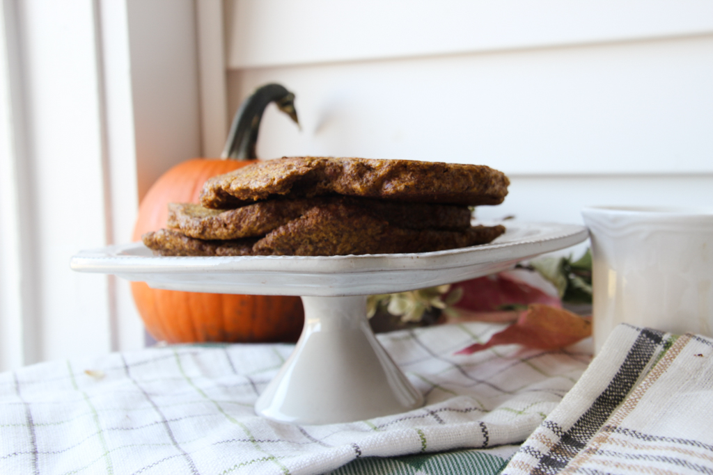 flaxseed pumpkin pancakes on a white display tray with a pumpkin in the background